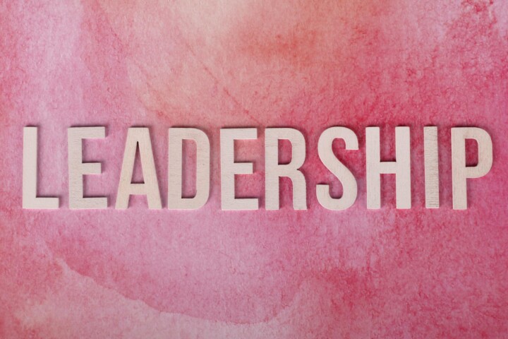 Inspirational leadership text on a vibrant pink watercolor background.