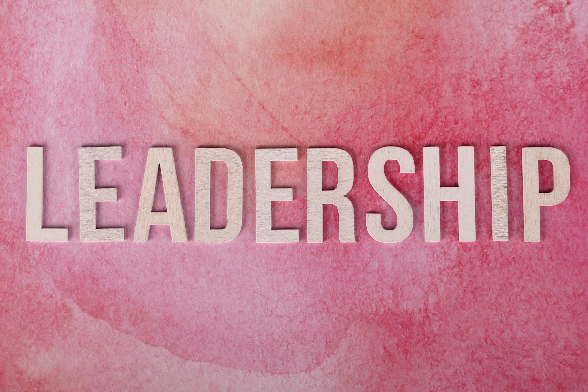 Inspirational leadership text on a vibrant pink watercolor background.